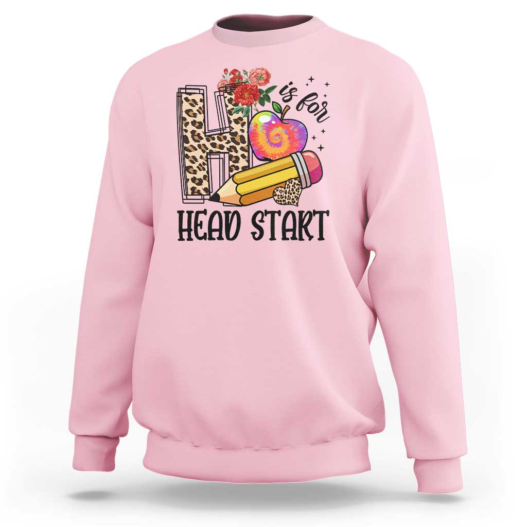 Light pink kids crewneck sweatshirt with “Head Start” pencil, apple, and flower graphic.