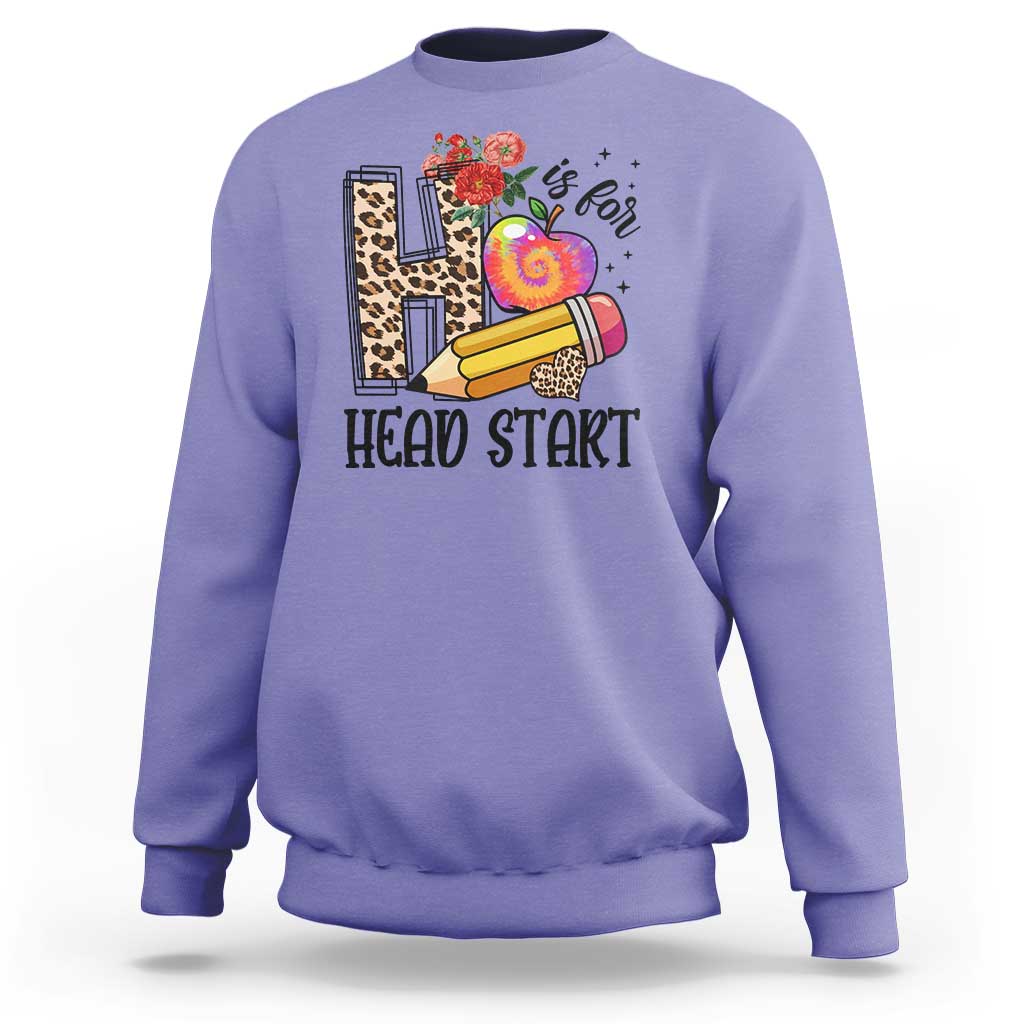 Violet kids crewneck sweatshirt with “Head Start” pencil, apple, and flower graphic.