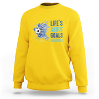 Yellow soccer sweatshirt with blue “Life’s About Goals (and Assists)” graphic on chest