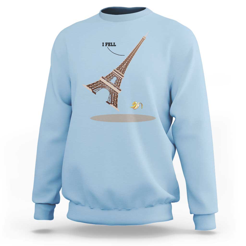 Light blue Eiffel Tower graphic sweatshirt with “I FELL” text and banana peel design