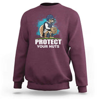 Maroon crewneck sweatshirt with baseball squirrel graphic and “PROTECT YOUR NUTS” print