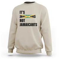 Beige sweatshirt with bold “It’s Jamaicans Not Jamaicants” text graphic on chest