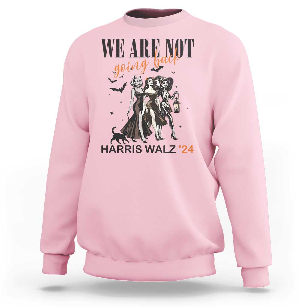 Light pink crewneck sweatshirt with 'WE ARE NOT' witch graphic, lantern, and 'HARRIS WALZ '24' text