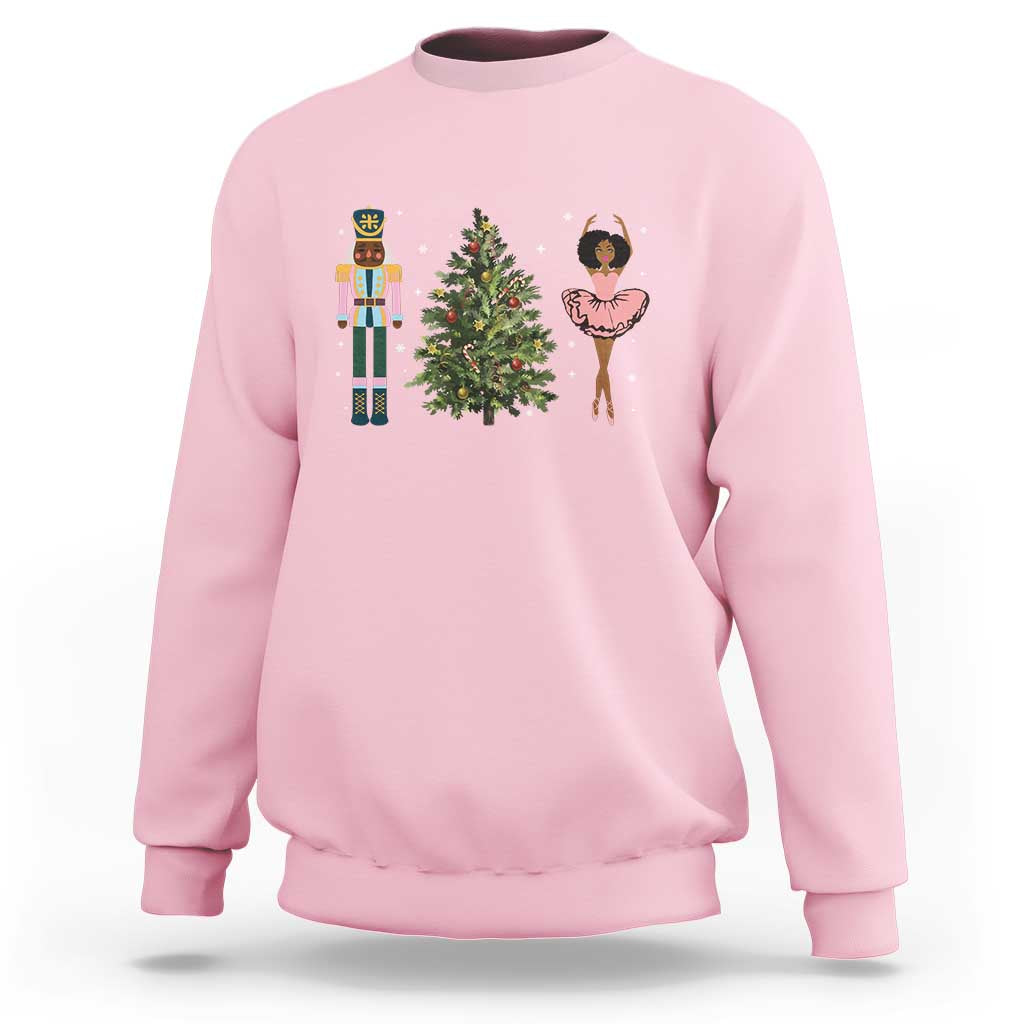 Light pink crewneck Christmas sweatshirt with nutcracker, tree, and ballerina graphic on chest