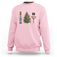 Light pink crewneck Christmas sweatshirt with nutcracker, tree, and ballerina graphic on chest