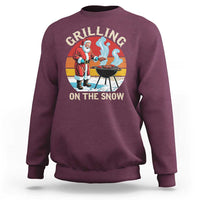 Maroon crewneck sweatshirt, back Santa grilling graphic: 'GRILLING ON THE SNOW'