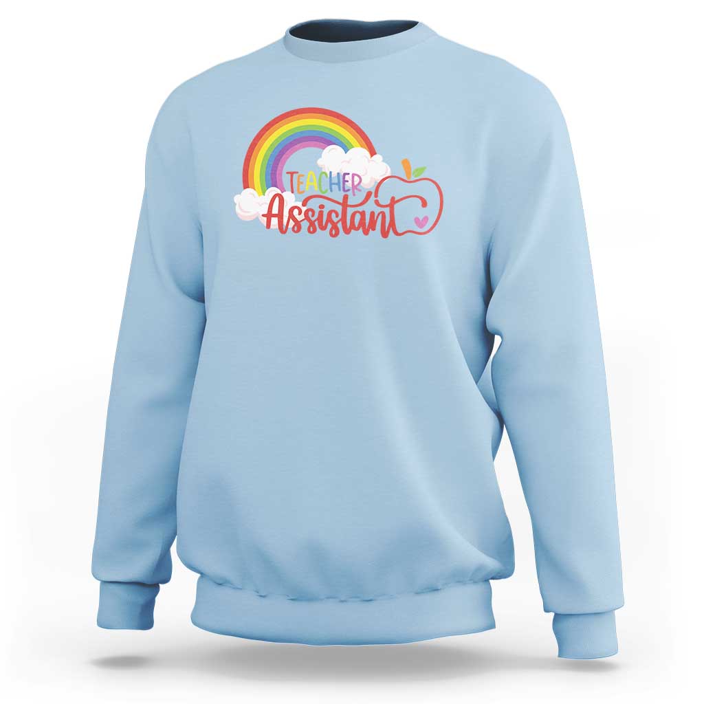 Light blue teacher assistant sweatshirt with rainbow cloud apple graphic on front.