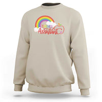 Sand teacher assistant sweatshirt with rainbow cloud apple graphic on front.