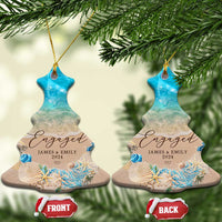 Personalized engagement Christmas ornament pair, tree shape with blue beach ocean and “Engaged”.