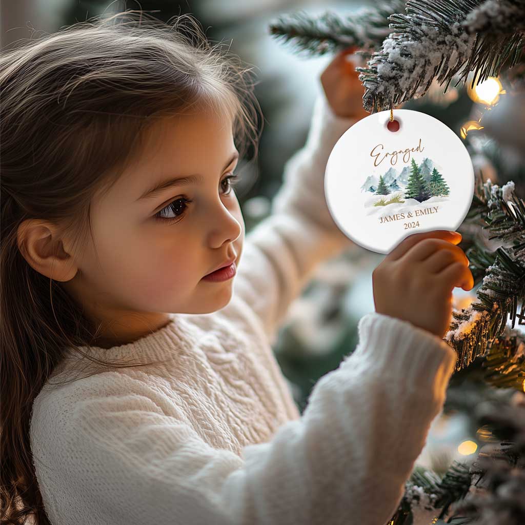 Engaged round Christmas ornament on gold string, snowy forest with JAMES & EMILY, 2024