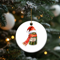 Round Christmas ornament with pickle jar wearing Santa hat and scarf, gold hanging loop
