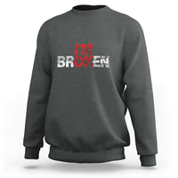 Charcoal gray crewneck sweatshirt with “BROKEN” red-and-white graphic on front
