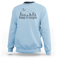 Light blue crewneck sweatshirt with “Keep it simple” forest and moon graphic