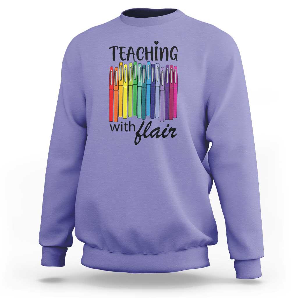 Violet sweatshirt with “Teaching with Flair” pencil graphic, crewneck long sleeves.