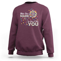Maroon crewneck sweatshirt with colorful dandelion dot graphic and motivational text on chest