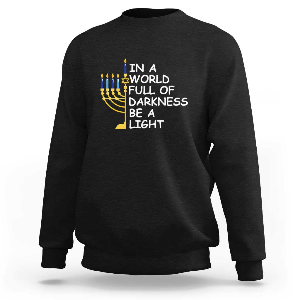 Men's Hanukkah sweatshirt in black with menorah and “IN A WORLD FULL OF DARKNESS” text