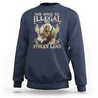 Navy crewneck sweatshirt with large eagle graphic and “No One Is Illegal on Stolen Land” text.