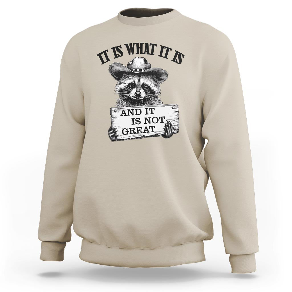 Sand raccoon sweatshirt with black quote text and raccoon hand graphic