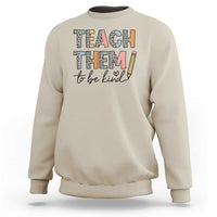 Sand teacher sweatshirt with “Teach Them” and “to be kind” pencil graphic on front.