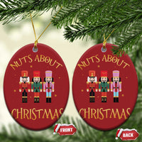 Set of 2 red oval ornaments reading “Nuts About Christmas” with nutcracker figures