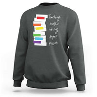 Charcoal sweatshirt with colorful stacked-book graphic and 'Teaching music is my super power' text.