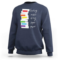 Navy sweatshirt with colorful stacked-book graphic and 'Teaching music is my super power' text.