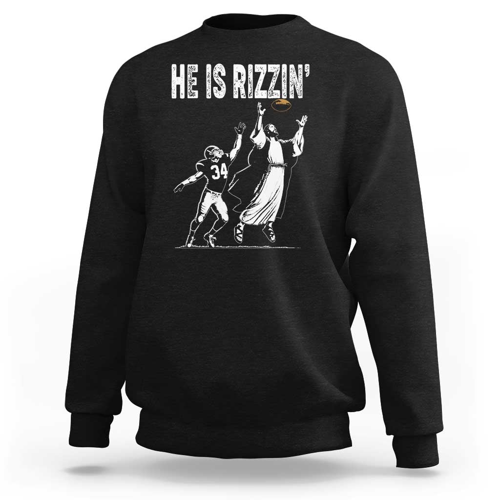 Black crewneck sweatshirt with football-themed Jesus graphic and “HE IS RIZZIN’” text