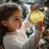 Gold round Christmas ornament in front of a child, “LET’S GET LIT” with colorful light icons