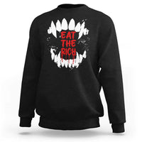 Black sweatshirt with white fang graphic and red “EAT THE RICH” text on back
