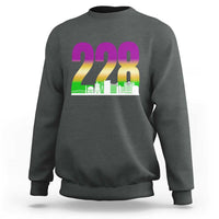 Dark heather gray crewneck sweatshirt with 228 colorful graphic and green skyline print