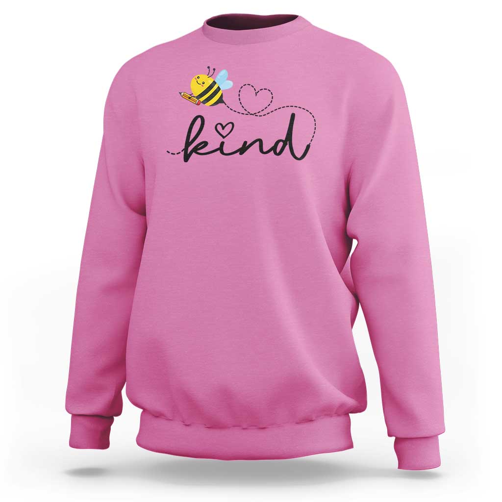 Light pink crewneck sweatshirt with bee and heart 'kind' graphic on chest.