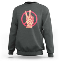 Charcoal gray crewneck sweatshirt with red peace-sign graphic and Harris 2024 text.