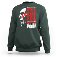Dark green crewneck sweatshirt with Native-inspired profile graphic and red stacked text front