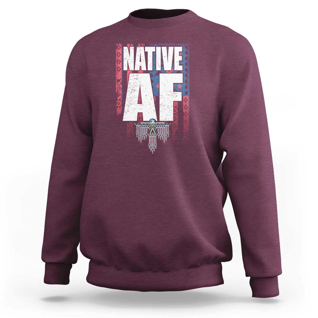 Maroon crewneck sweatshirt with centered Native-inspired graphic print and ribbed cuffs