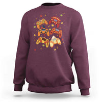 Maroon gaming sweatshirt with colorful controller-and-autumn icons graphic on front