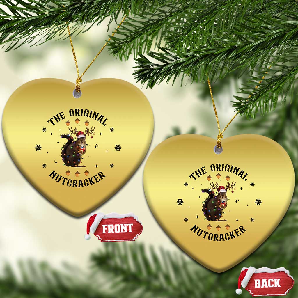 Gold heart-shaped Christmas ornament with nutcracker squirrel graphic, two hanging.