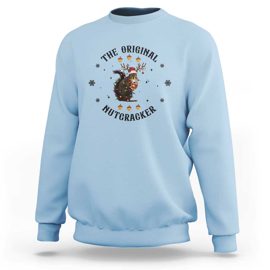Light blue crewneck sweatshirt with nutcracker graphic and winter snowflake accents