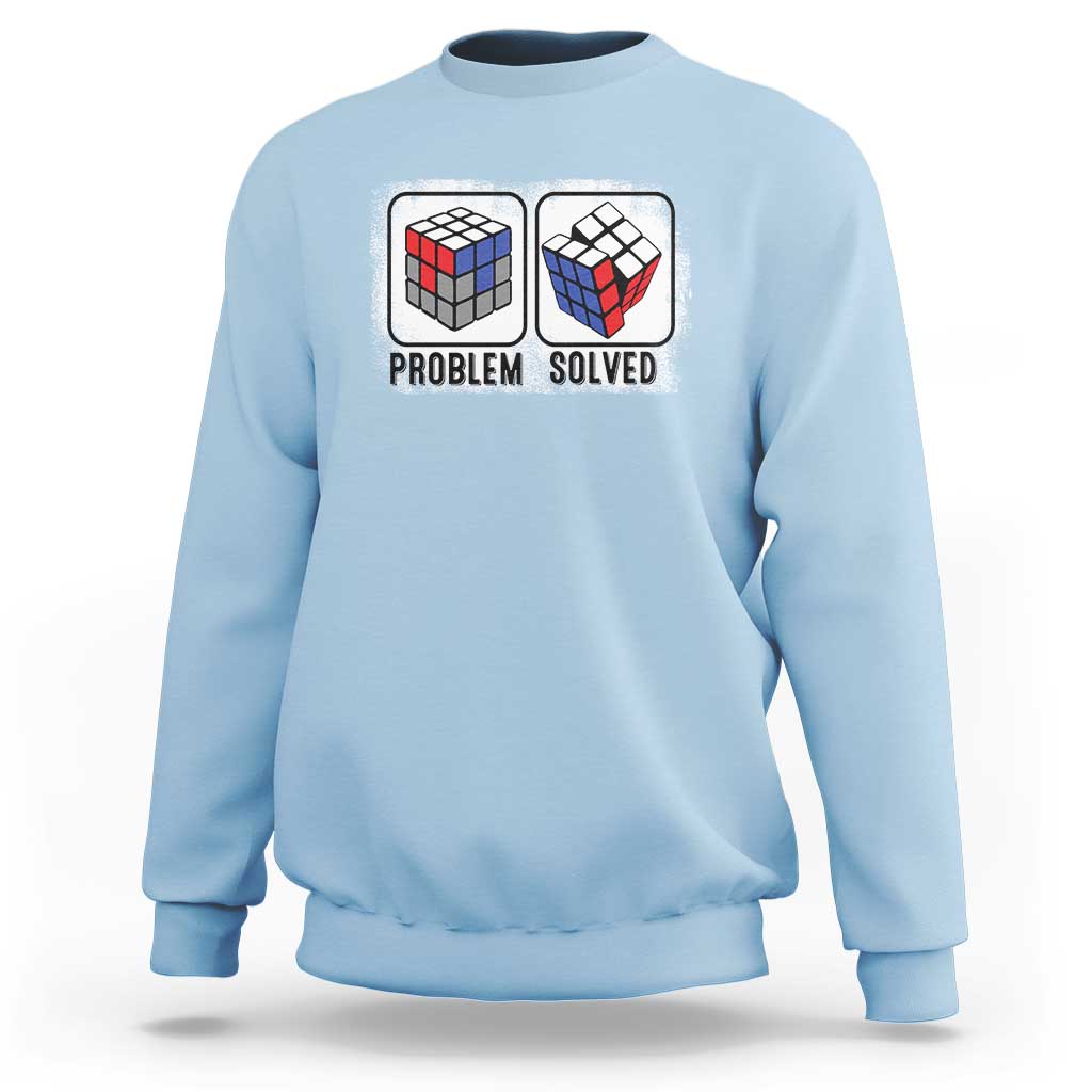 Light blue crewneck sweatshirt with “Problem Solved” puzzle cube graphic