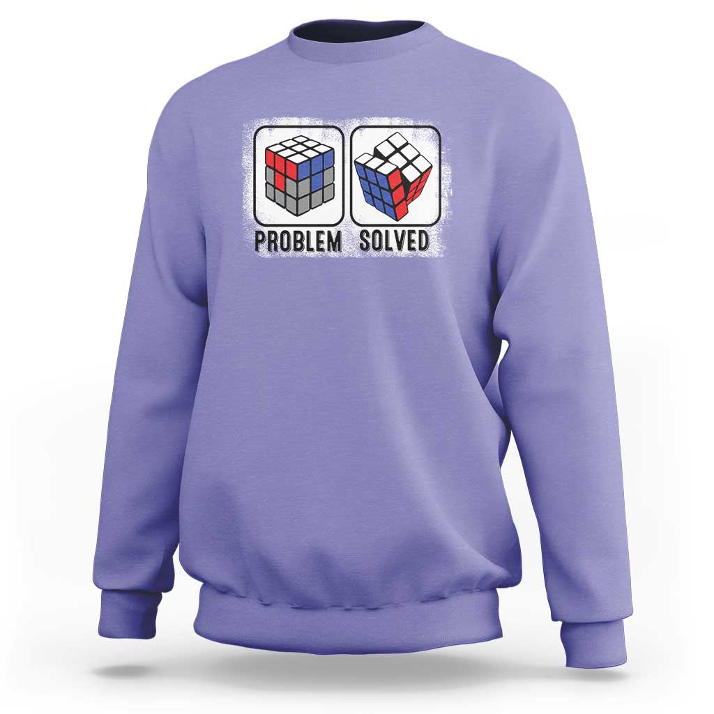Violet crewneck sweatshirt with “Problem Solved” puzzle cube graphic