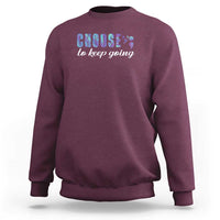 Maroon crewneck sweatshirt with front “choose to keep going” colorful graphic.