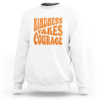 White sweatshirt with orange 'Kindness Takes Courage' graphic on front.