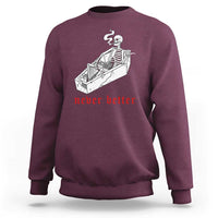 Maroon skeleton graphic sweatshirt with coffin illustration and red “never better” text
