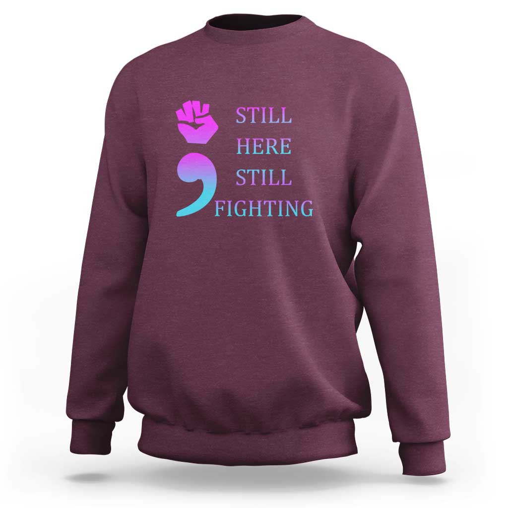 Maroon crewneck sweatshirt with “STILL HERE STILL FIGHTING” graphic and semicolon symbol
