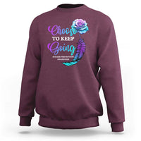 Maroon crewneck sweatshirt with front rose-feather awareness graphic.