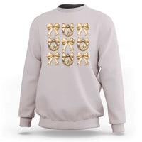 Light mauve sweatshirt with gold bow and plaid ornament graphic on front