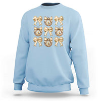 Light blue sweatshirt with gold bow and plaid ornament graphic on front