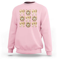 Light pink sweatshirt with gold bow and plaid ornament graphic on front