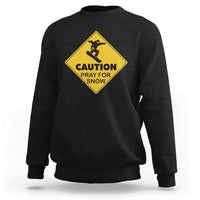 Black crewneck sweatshirt with yellow “CAUTION PRAY FOR SNOW” snowboard graphic