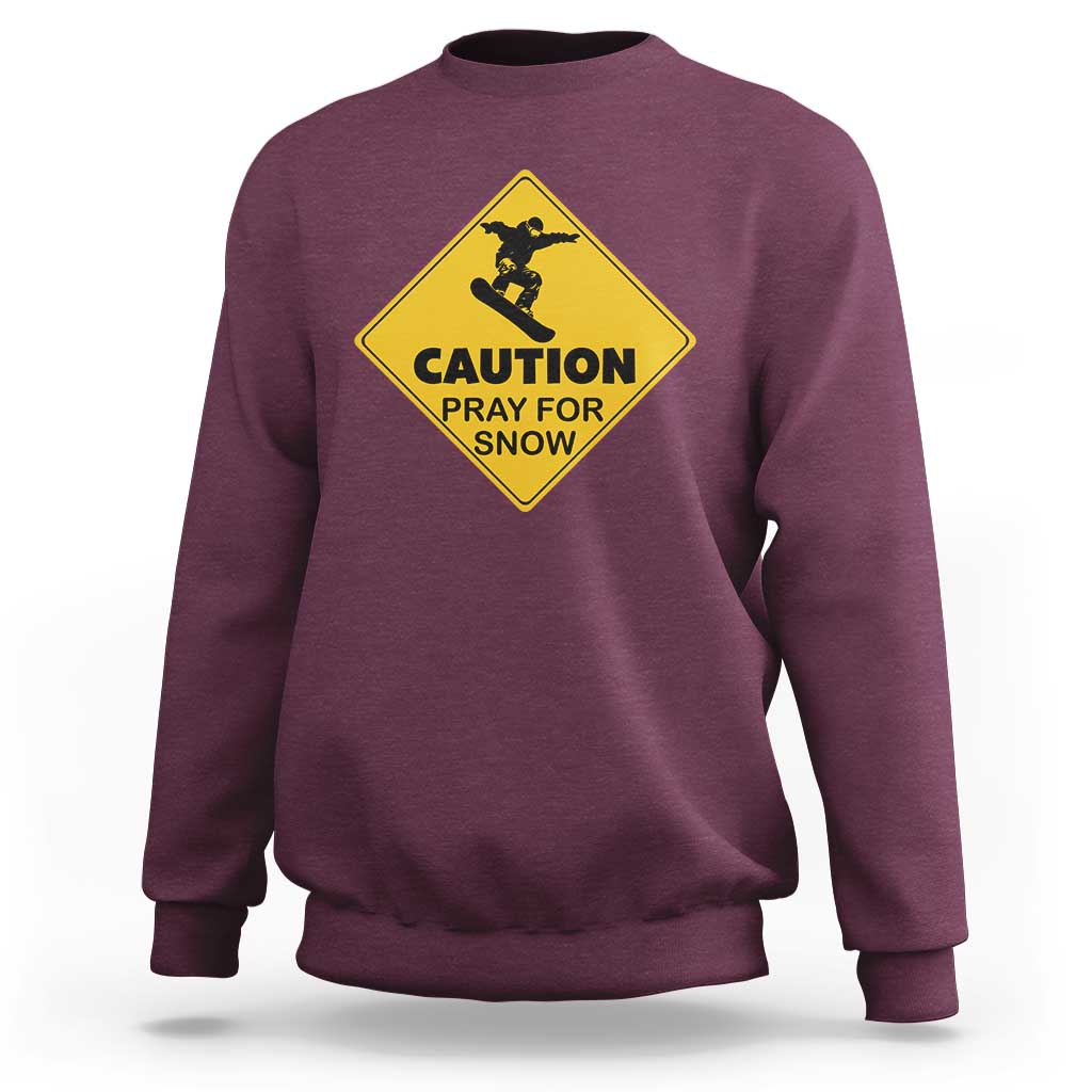 Maroon crewneck sweatshirt with yellow “CAUTION PRAY FOR SNOW” snowboard graphic