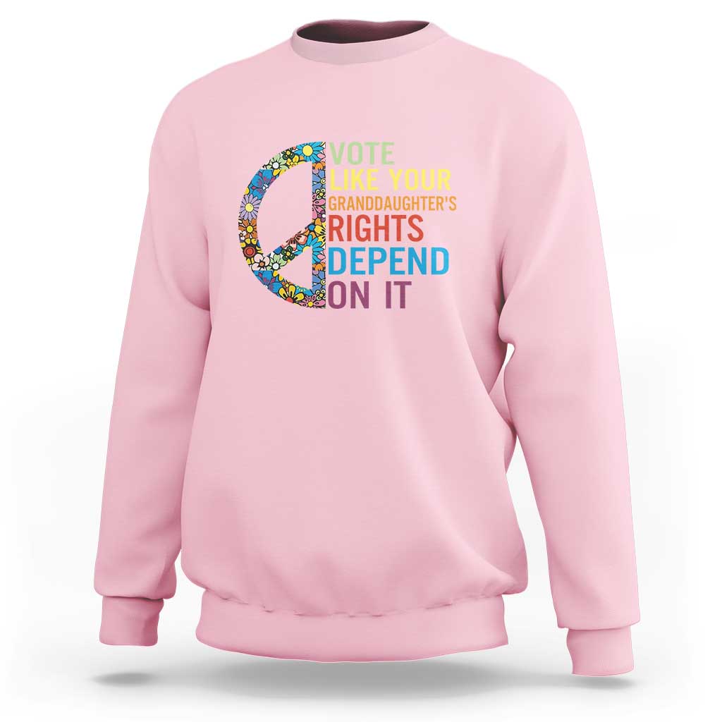 Light pink crewneck graphic sweatshirt with floral peace sign and voting text design